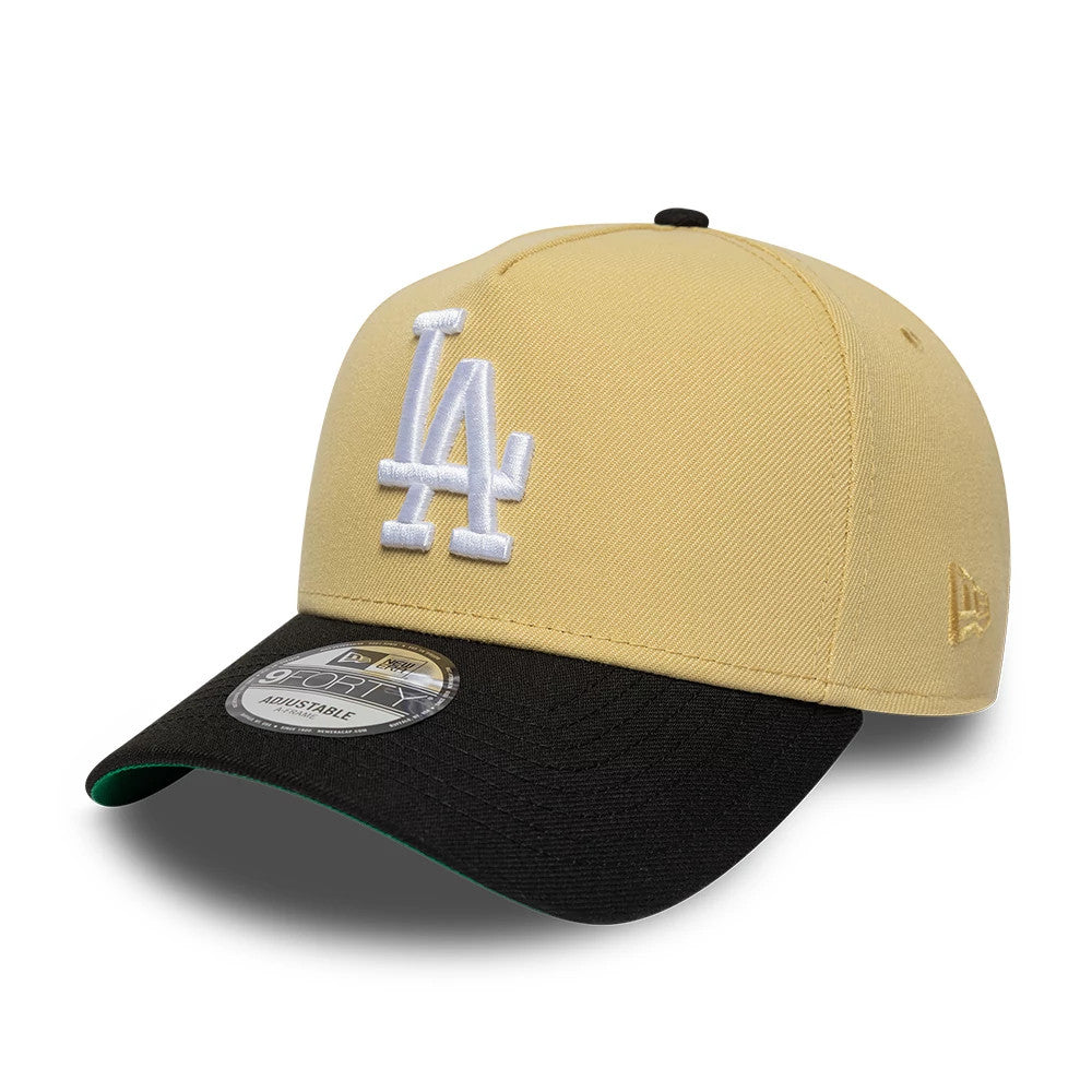 LA Dodgers MLB Vegas Gold New Era 9FORTY A-Frame Cap, three-quarter view showing the raised white LA logo embroidered on the vegas gold front panel, black curved visor with a 9FORTY size sticker, and gold New Era flag on the left side.
