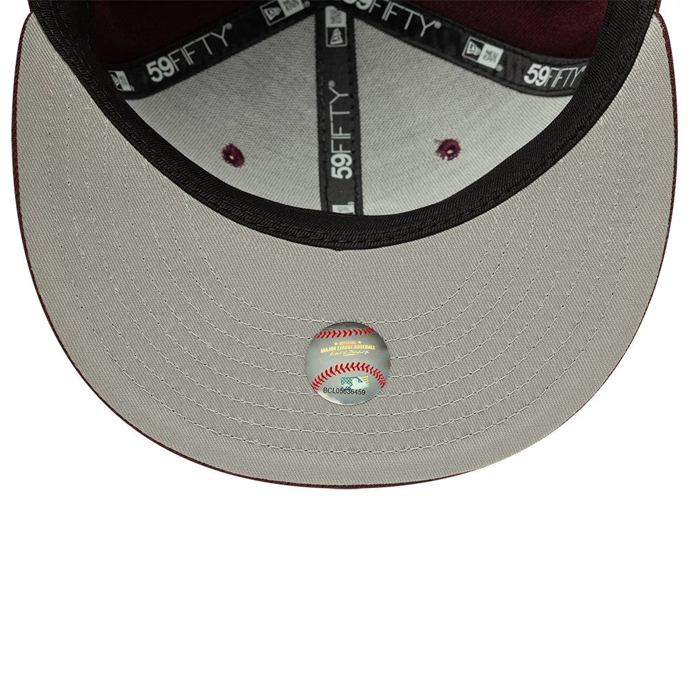 Athletics MLB Dark Purple New Era 59FIFTY Fitted Cap, inside view showing black taping with white 59FIFTY logos, grey undervisor with a baseball sticker at the centre, and contrasting dark purple eyelets and interior panels.