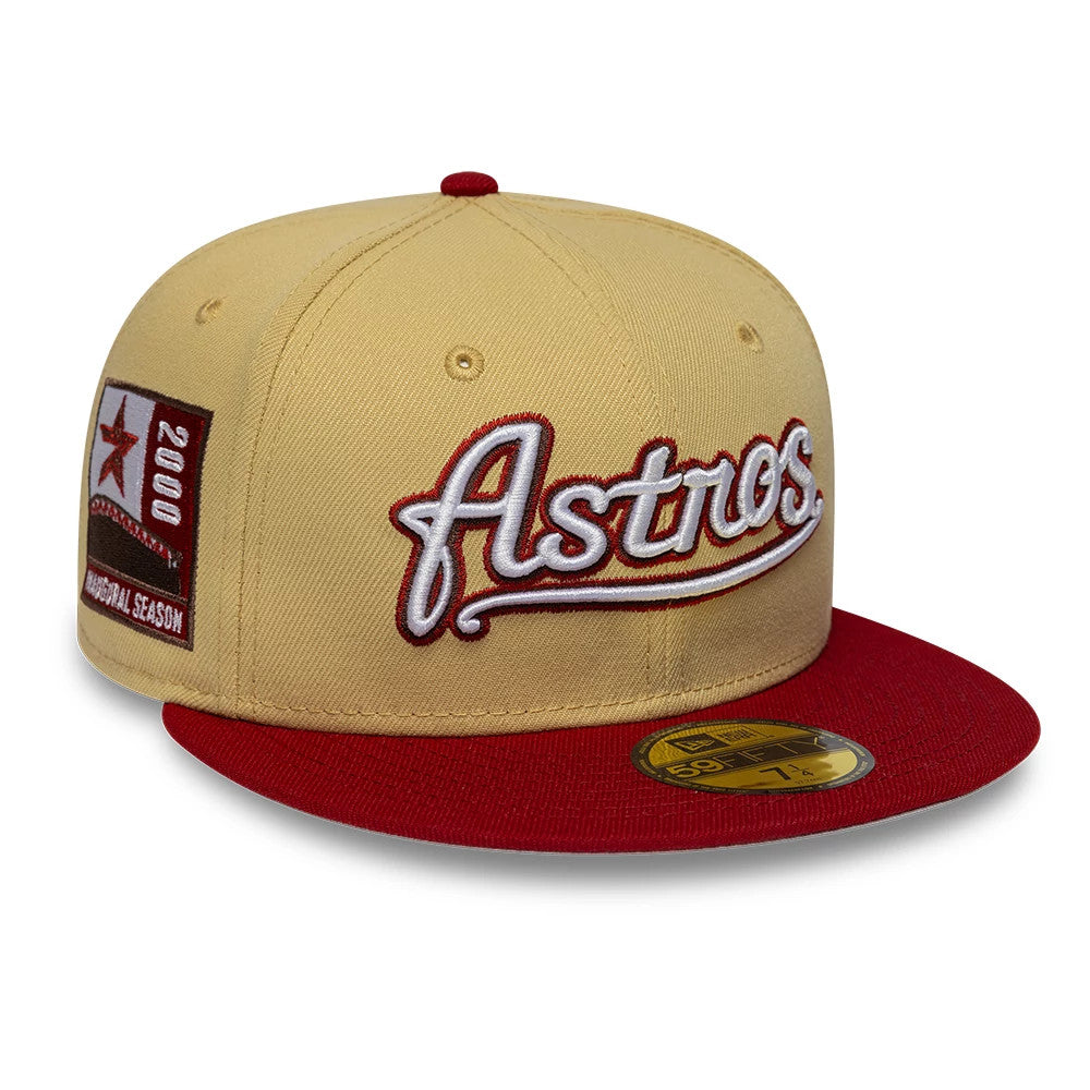 Houston Astros MLB Vegas Gold New Era 59FIFTY Fitted Cap, three-quarter view showing raised red and white Astros script on the front, a commemorative side patch on the left panel, and a contrasting red flat visor with a gold 59FIFTY size sticker.