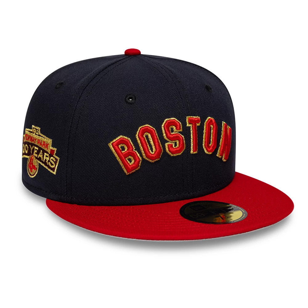 Boston Red Sox MLB Cooperstown Navy New Era 59FIFTY Fitted Cap, three-quarter view showing red and gold embroidered BOSTON lettering on the front panel, a red flat visor with a gold 59FIFTY size sticker, and a commemorative side patch.