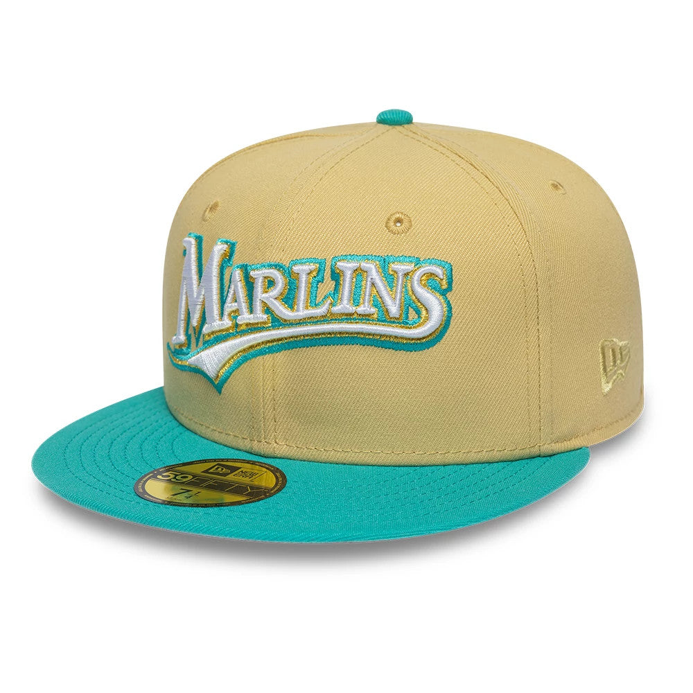 Florida Marlins MLB Vegas Gold & Turquoise New Era 59FIFTY Fitted Cap, three-quarter view showing the raised white Marlins logo with turquoise outline on the front panel, turquoise flat visor, and the New Era flag logo embroidered on the left side.