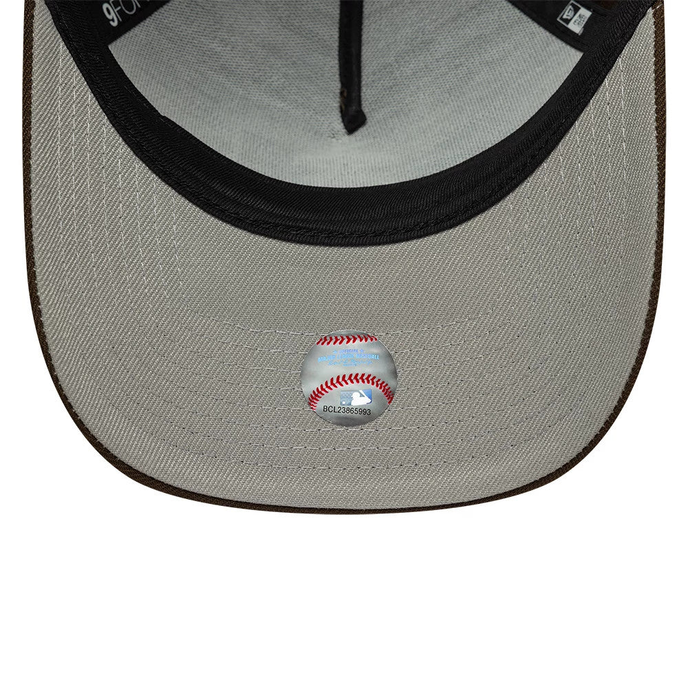 LA Angels MLB Dark Brown New Era 9FORTY A-Frame Adjustable Cap, inside view showing the grey undervisor with a round authenticity sticker featuring red baseball stitching, black sweatband along the edge, and New Era taping above.