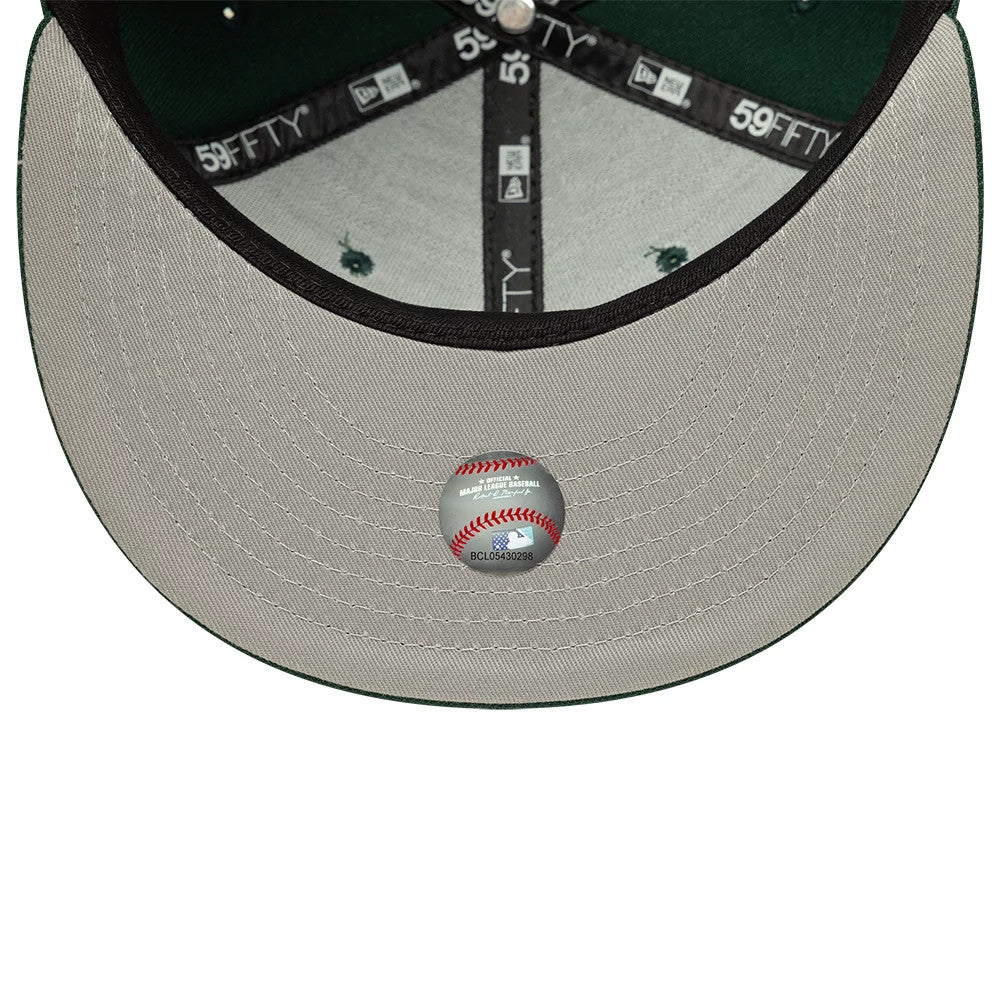 Athletics MLB Dark Green New Era 59FIFTY Fitted Cap, inside view showing grey undervisor with central baseball-themed sticker, black branded taping along the seams, and forest green crown interior, highlighted by eyelets.
