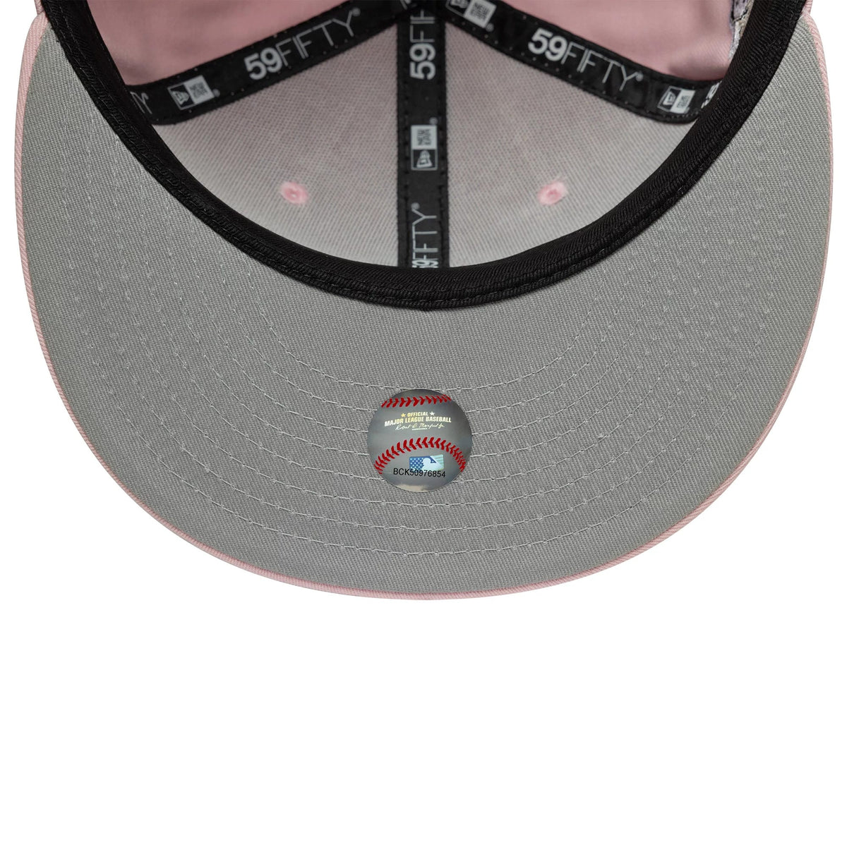 New York Yankees MLB World Series Pink New Era 59FIFTY Fitted Cap, inside view showing a grey undervisor with a baseball-themed sticker, black 59FIFTY taping with white text, and a light pink interior sweatband.