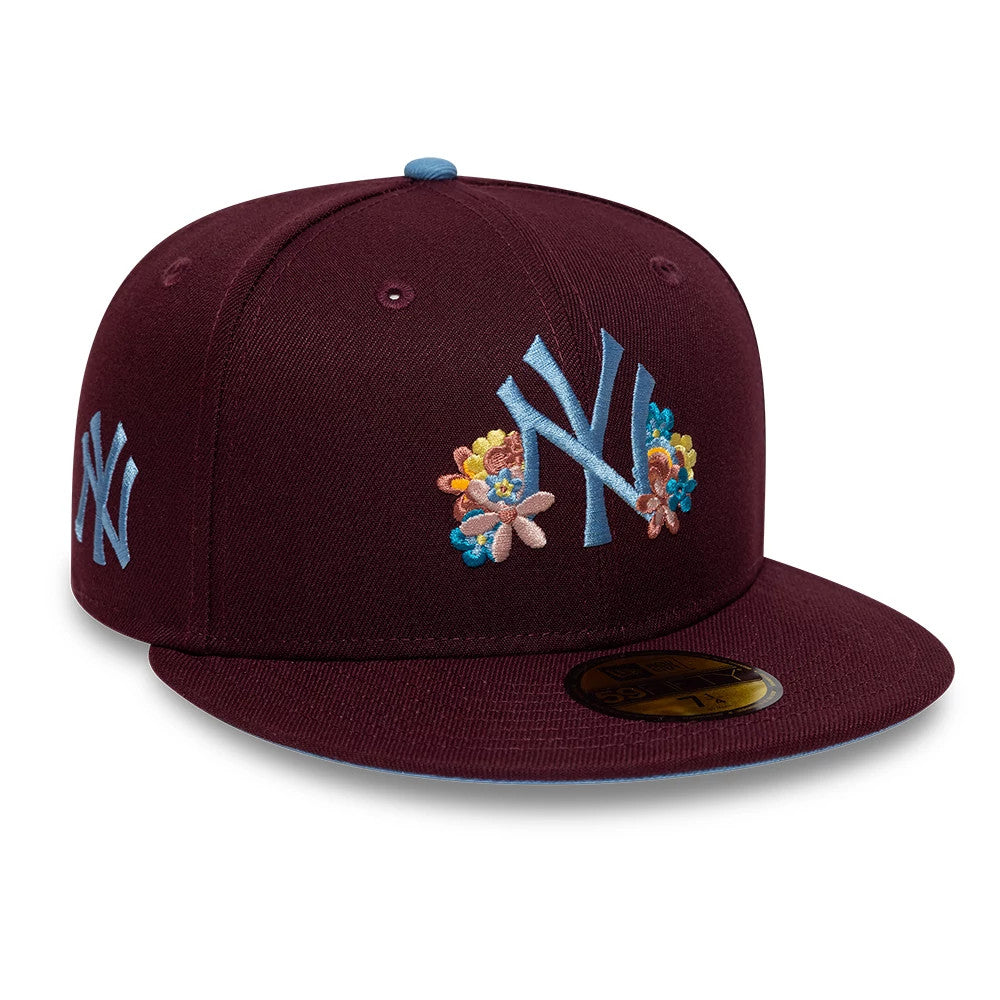 New York Yankees MLB Floral Dark Purple New Era 59FIFTY Fitted Cap, front view showing the light blue embroidered NY logo with colourful floral accents on the front panels, a flat dark purple visor, and a gold 59FIFTY size sticker.