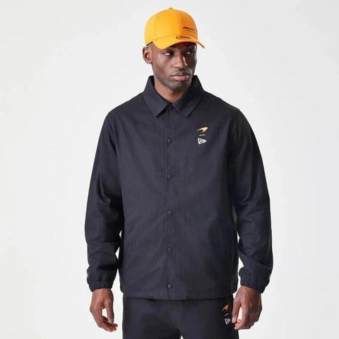 Slide 13:Man wearing a black jacket with a logo and a yellow cap on a white background