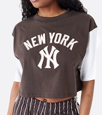 close up of female model wearing a white and brown yankees crop top