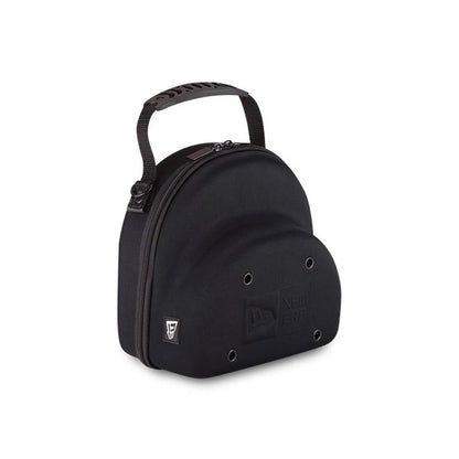 New Era Black 2 Cap Carry Case, three-quarter view showing the rounded black shell with eyelets on the front, a debossed New Era logo beneath them, and a short carry handle attached to the top with a side zip closure.