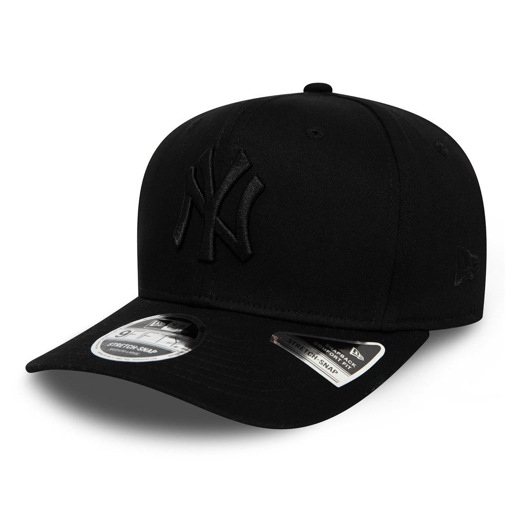 New York Yankees Tonal Black New Era 9FIFTY Stretch Snap Cap, three-quarter view showing the raised black embroidered NY logo on the front panel, with a 9FIFTY size sticker on the visor and the New Era flag logo on the left side.