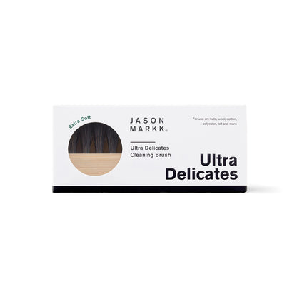 Jason Markk® Ultra Delicates Wooden Cap Brush, front view showing the boxed packaging with a circular window revealing soft black bristles and wooden handle, labelled for use on hats and delicate fabrics.