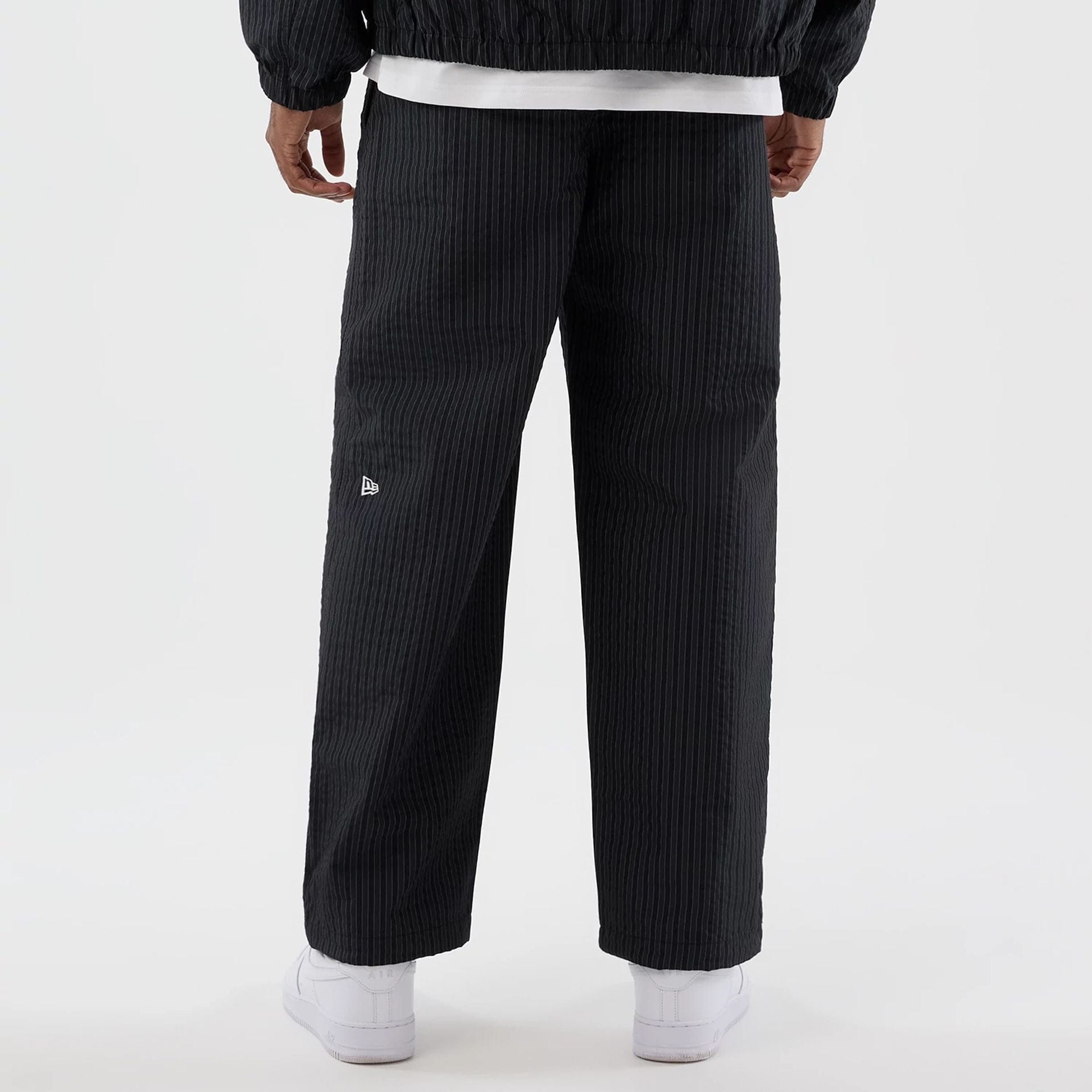 The model is wearing these New Era Street Class straight leg joggers in navy. 6