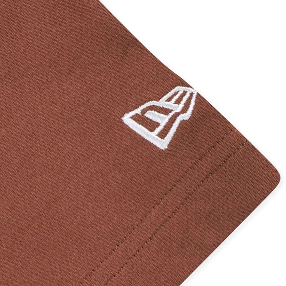 New Era Mountain Logo Open Brown T-Shirt, close-up view showing the white embroidered logo on the lower sleeve corner of the brown fabric.