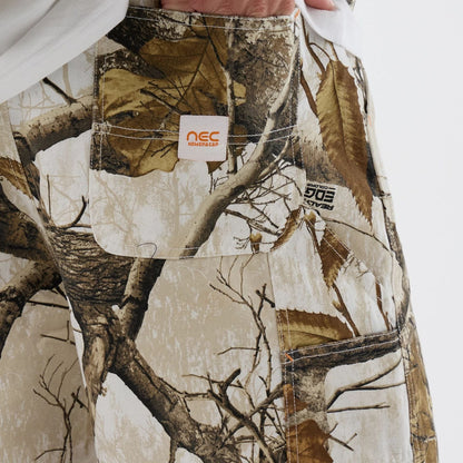 The Male model is wearing  New Era Earthy Skin Real Tree Snow Oversized Shorts  3