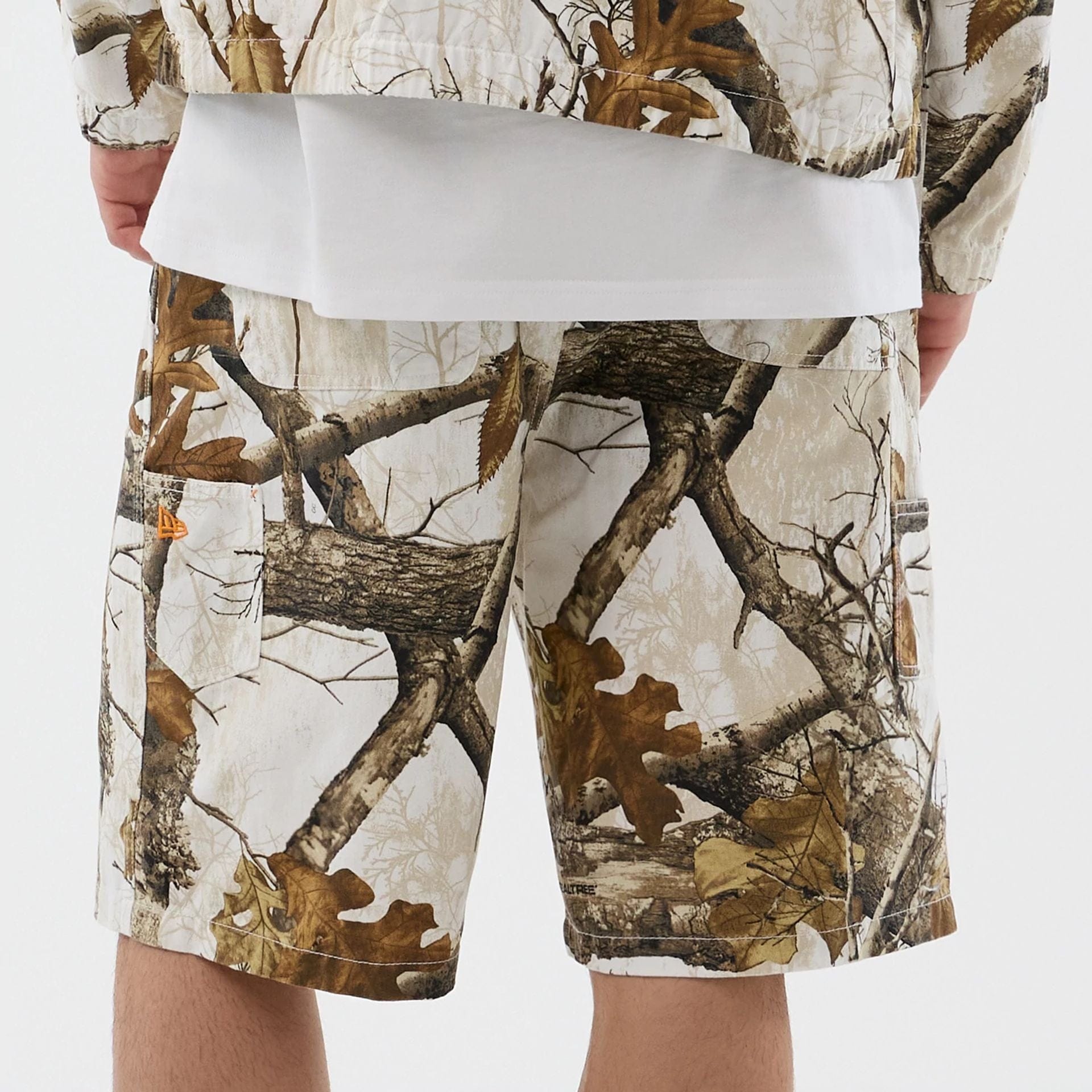 The Male model is wearing  New Era Earthy Skin Real Tree Snow Oversized Shorts  6