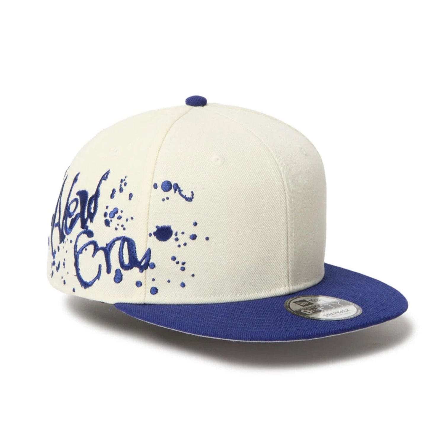 This is a New Era Dripping Emblem Cream 9FIFTY Snapback Adjustable Cap 1