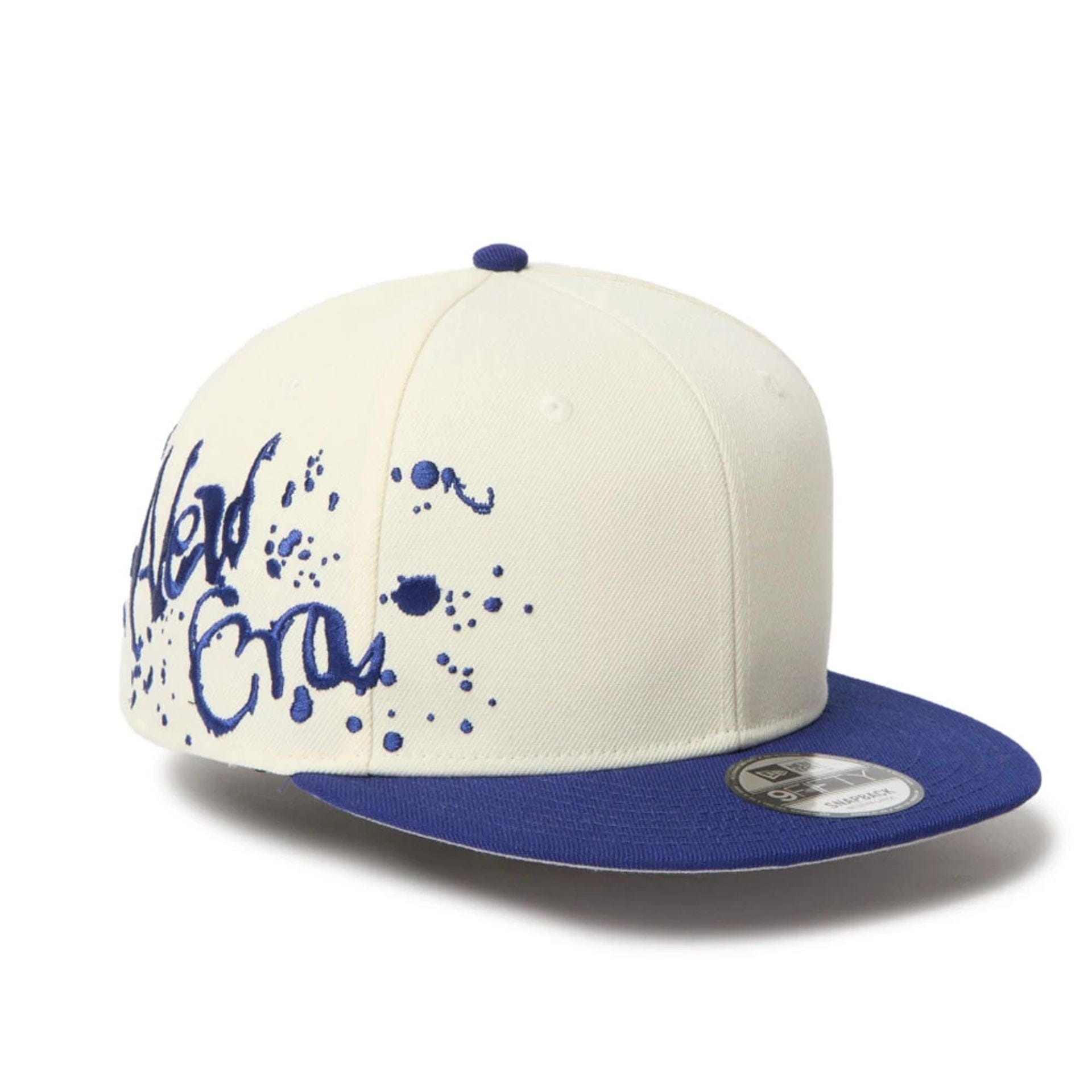 This is a New Era Dripping Emblem Cream 9FIFTY Snapback Adjustable Cap 1