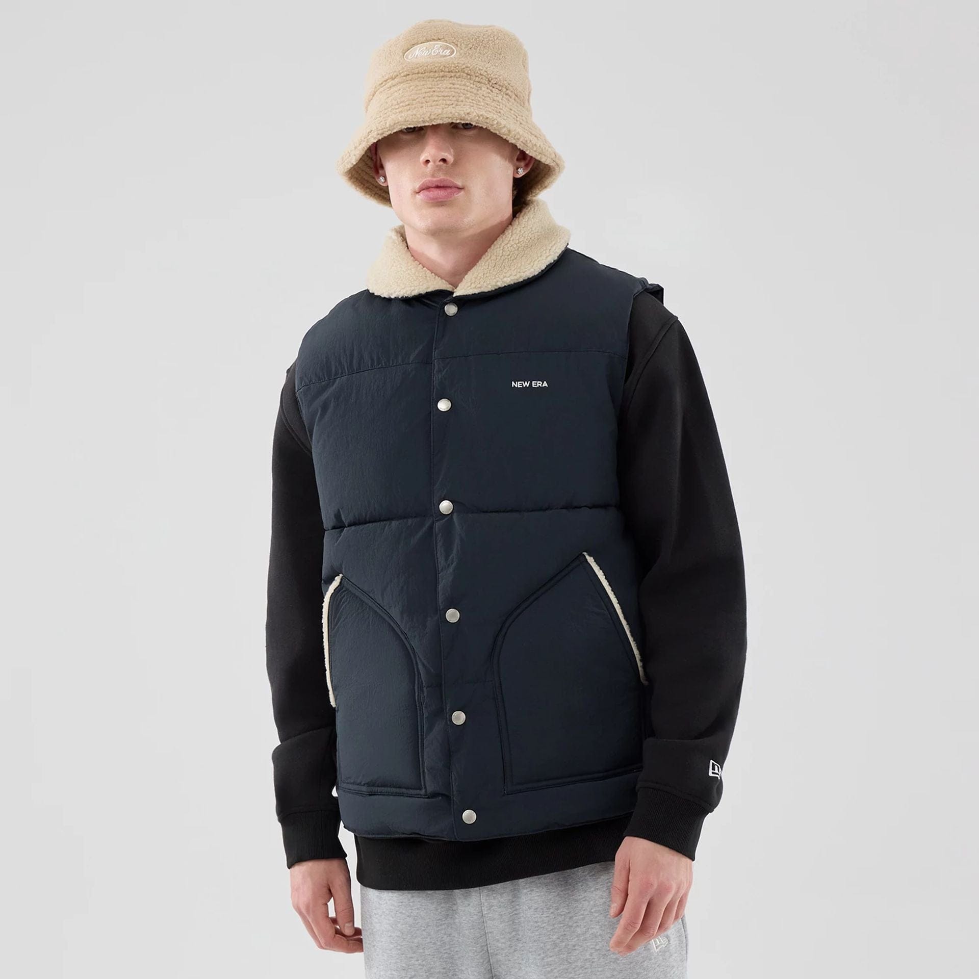 The Male model is wearing  New Era Organic Boa Neck Navy Gilet  3