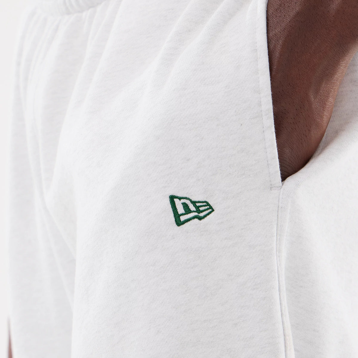LA Dodgers MLB Comfort Grey Joggers, close-up showing the green embroidered New Era flag logo on the left side near the pocket, with an elasticated waistband and soft grey fabric texture.