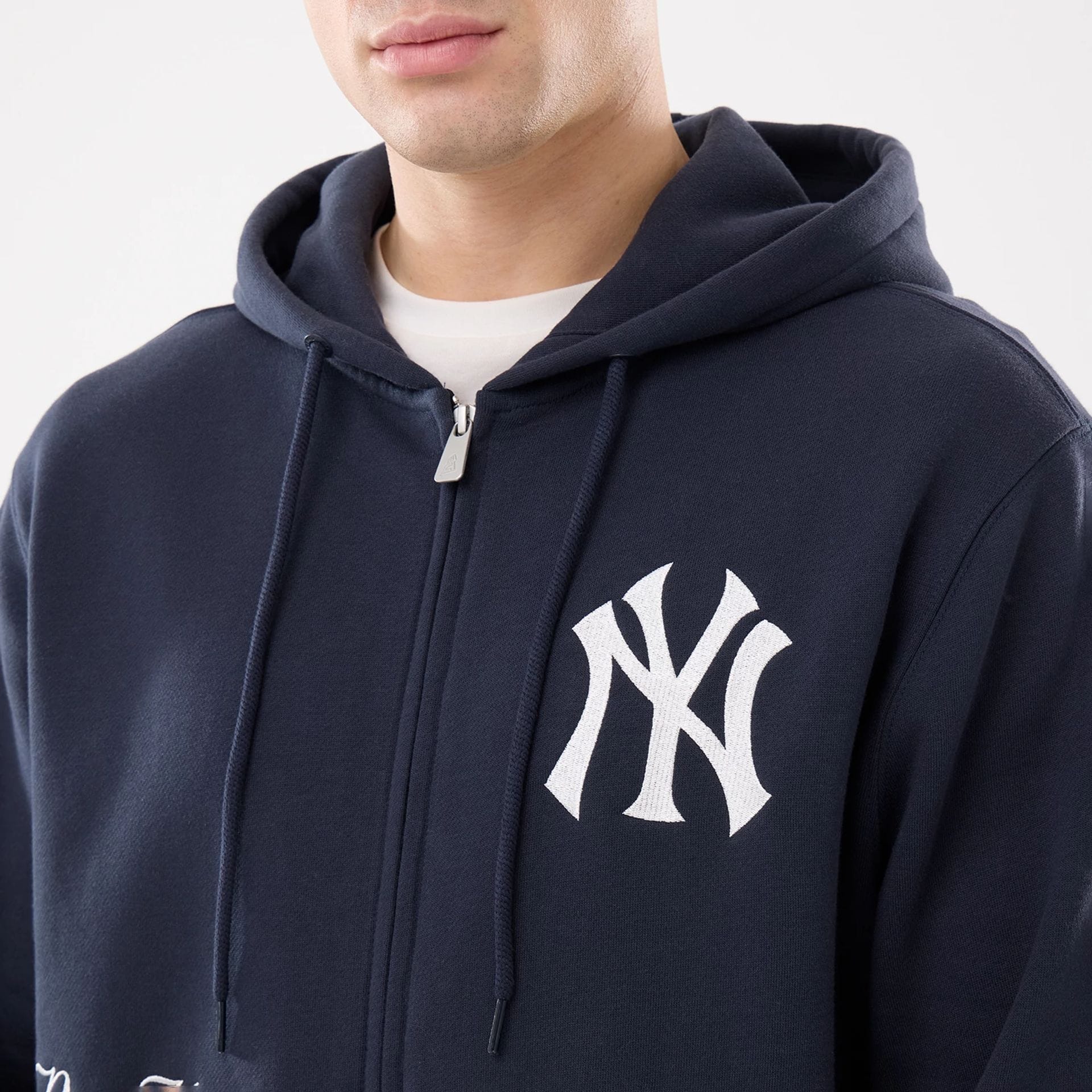 The model is wearing this MLB Comfort New York Yankees 2 Way Full Zip Hoodie in navy. 4