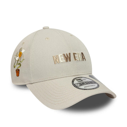 New Era Earth Day Beige New Era 9FORTY Adjustable Cap, three-quarter view featuring the beige embroidered New Era logo on the front panel, a flower design on the side, and a 9FORTY size sticker on the curved visor.