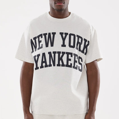 New York Yankees MLB Comfort Grey T-Shirt, front view showing large navy text across the chest reading "New York Yankees" on a light grey background, worn by a person standing with arms relaxed at their sides.