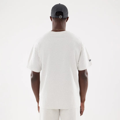 New York Yankees MLB Comfort Grey T-Shirt, rear view showing the plain grey fabric with a small black embroidered New Era logo on the left sleeve and a person wearing a black cap with a debossed New Era logo at the back.