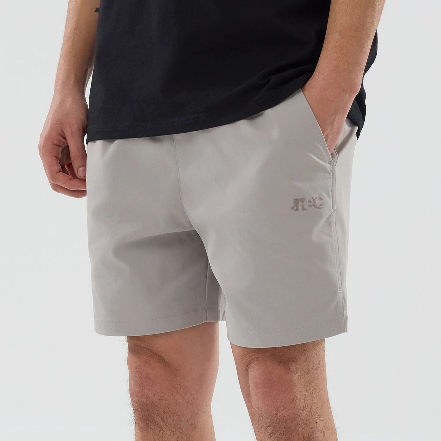 The model is wearing this New Era NEC Logo Oversized Shorts in Beige . 3