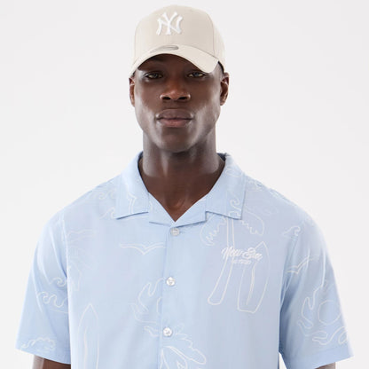 The model is wearing this New Era Resort Short Sleeve Shirt in blue. 6