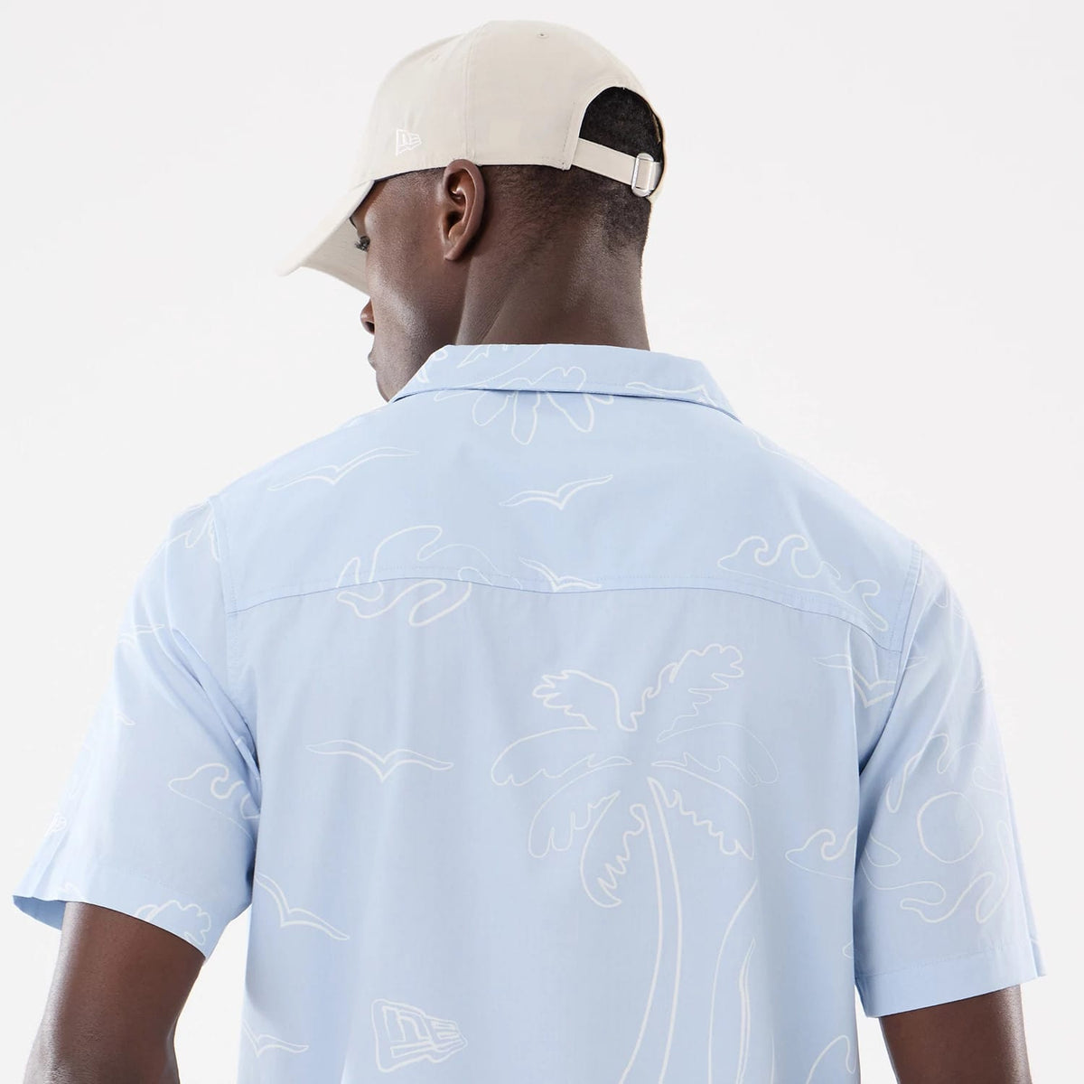 The model is wearing this New Era Resort Short Sleeve Shirt in blue. 7