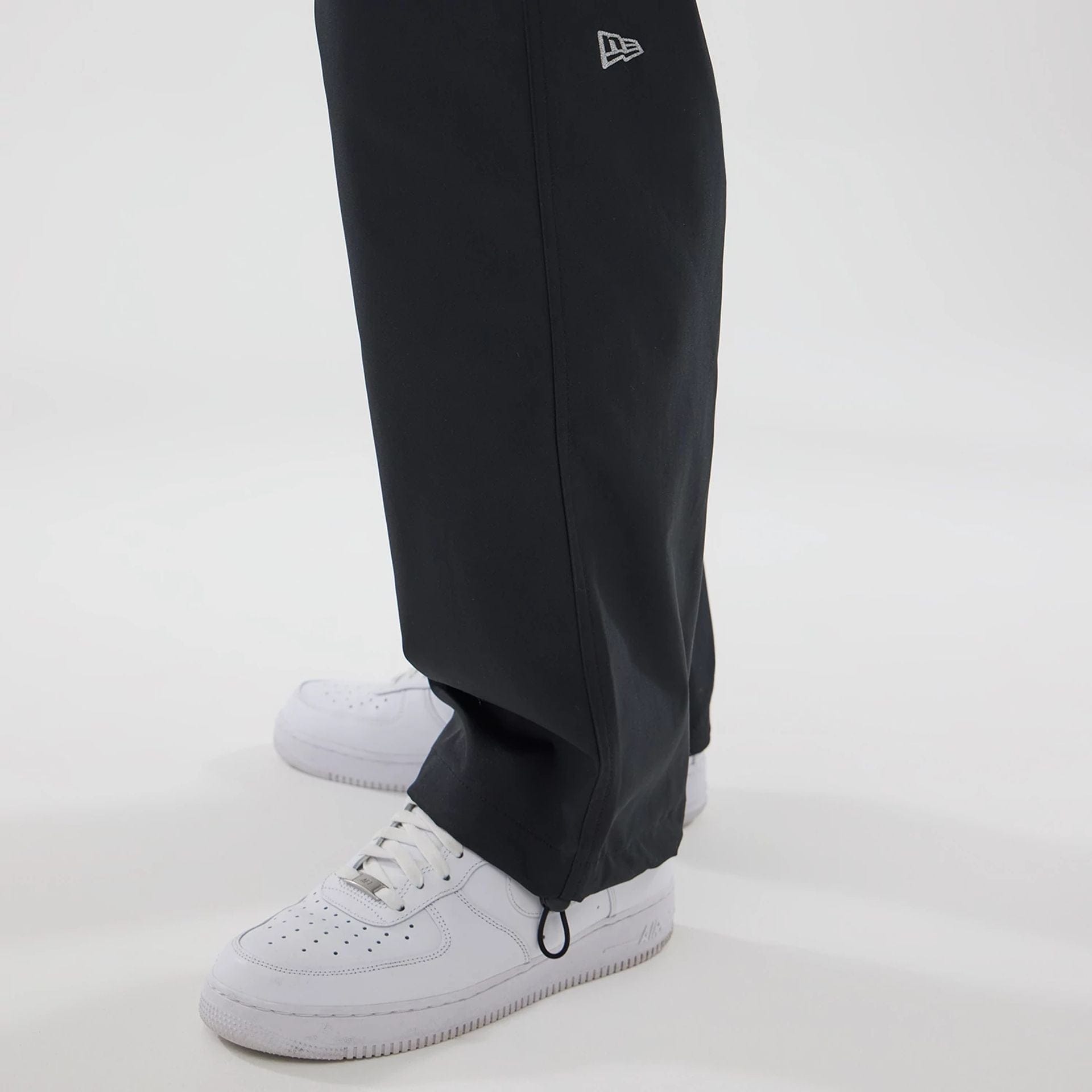 The model is wearing this New Era NEC Logo Straight Leg Joggers in black. 5
