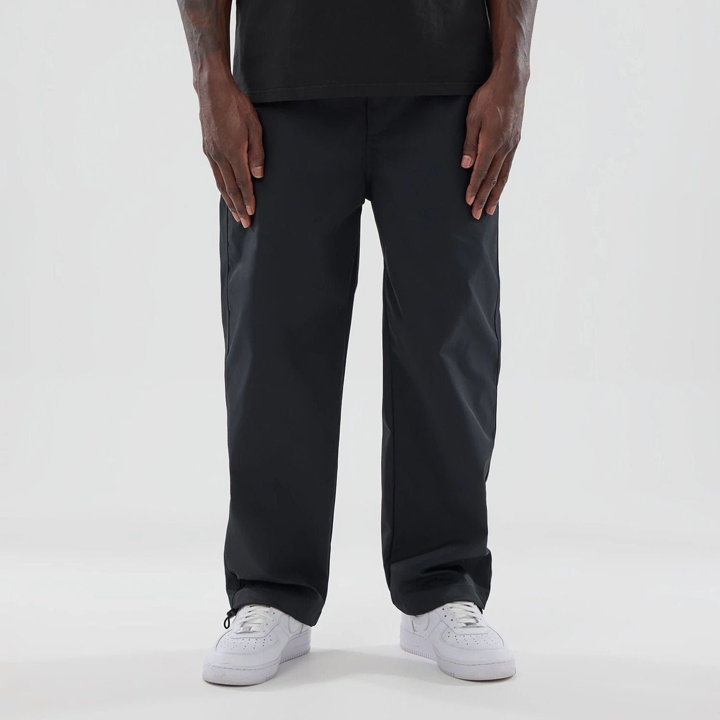 The model is wearing this New Era NEC Logo Straight Leg Joggers in black. 1