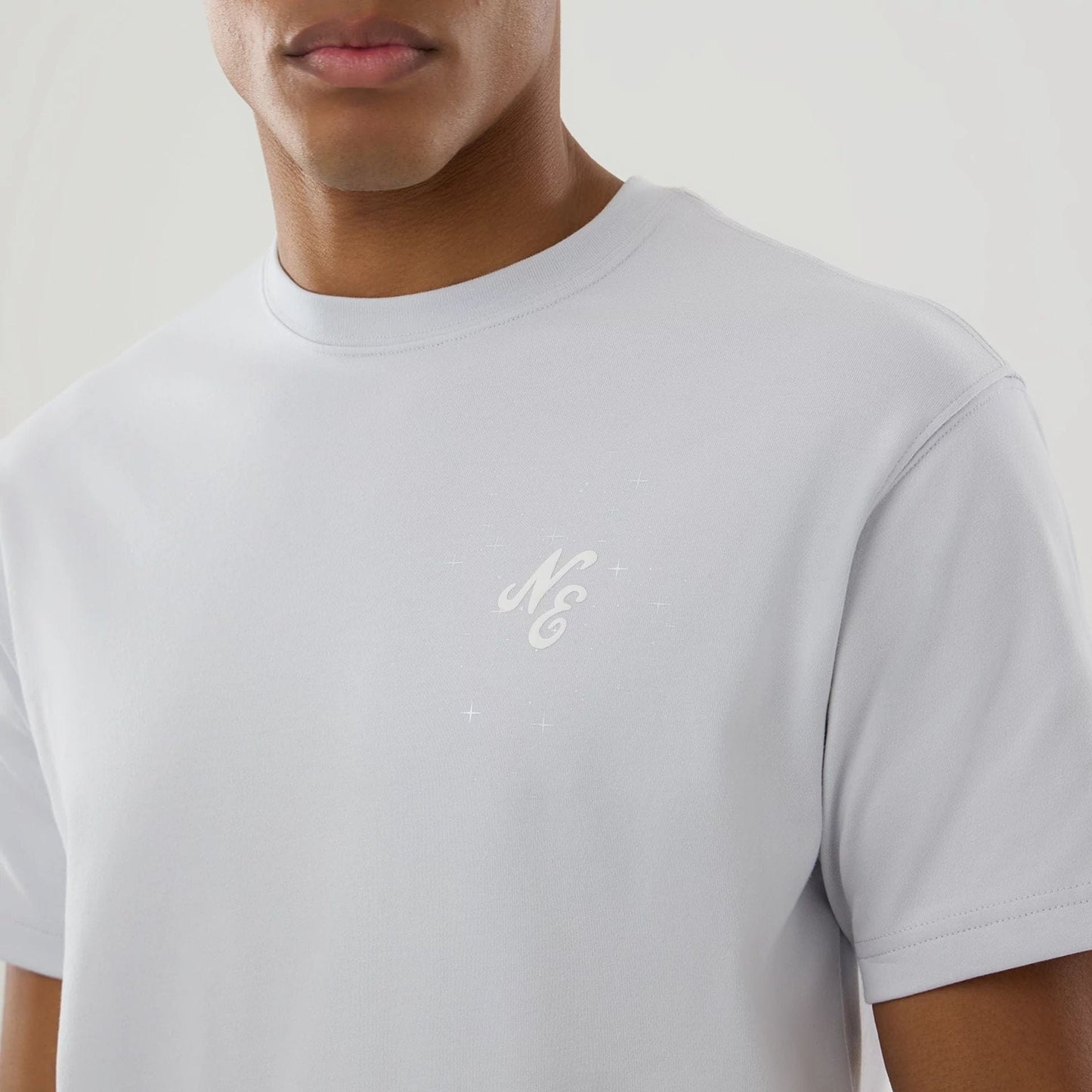 The model is wearing this New Era Zodiac Sign T-Shirt in silver. 5