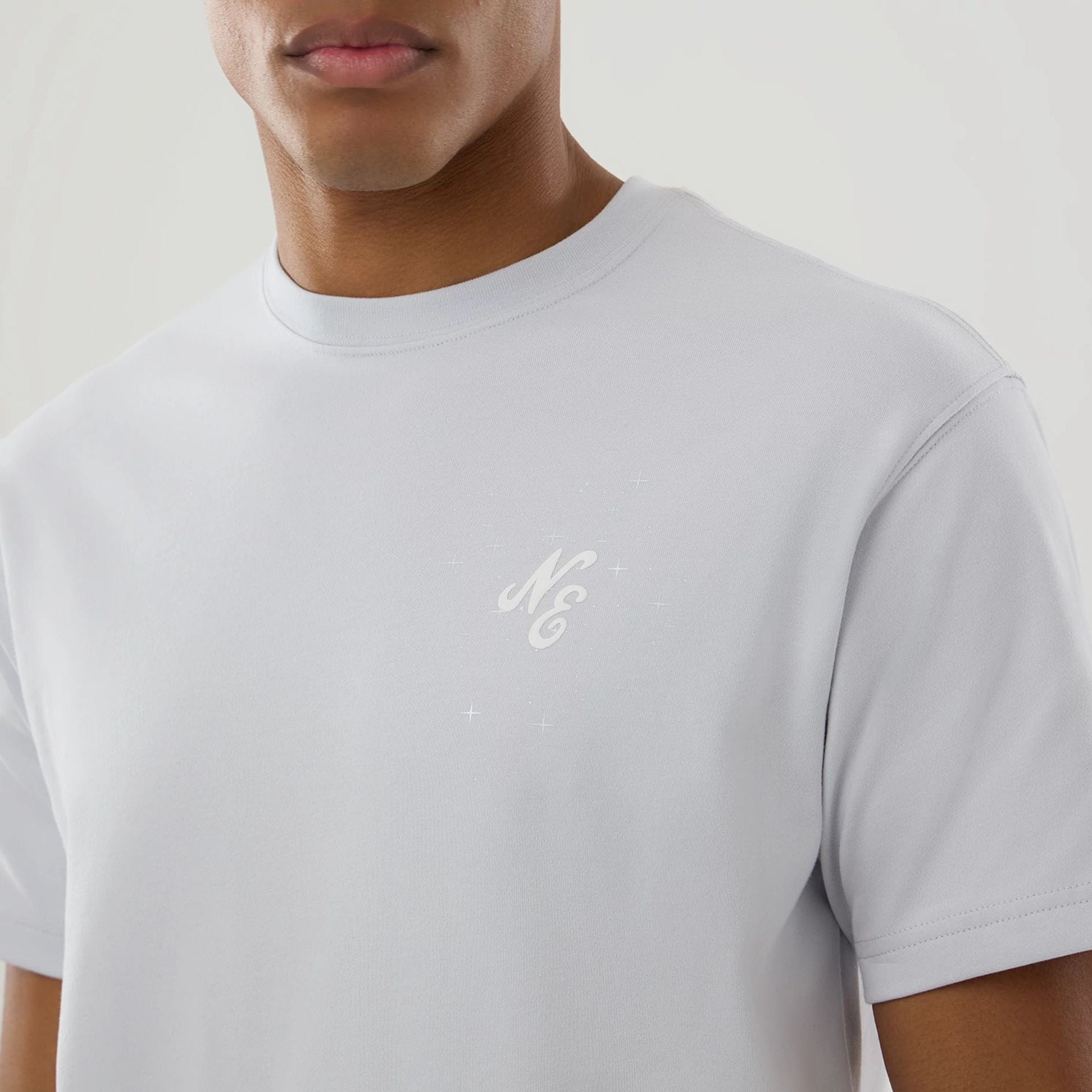 The model is wearing this New Era Zodiac Sign T-Shirt in silver. 5