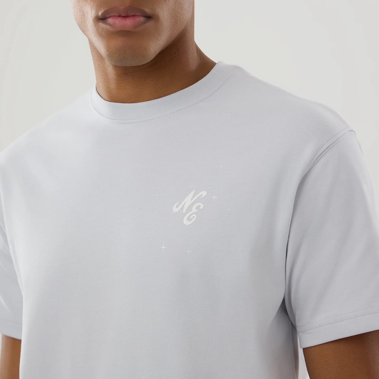 The model is wearing this New Era Zodiac Sign T-Shirt in silver. 5