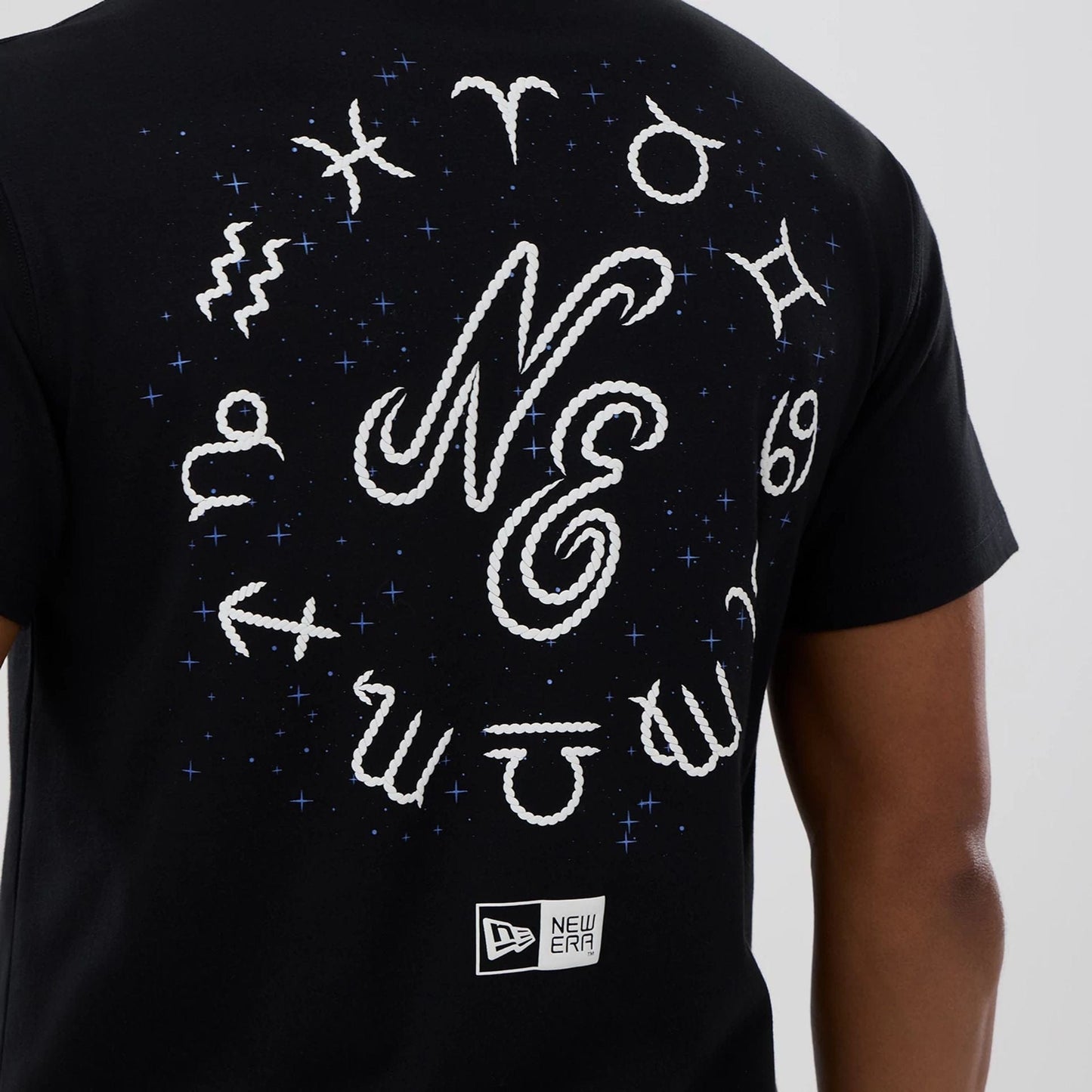 The model is wearing this New Era Zodiac Sign T-Shirt in black. 3