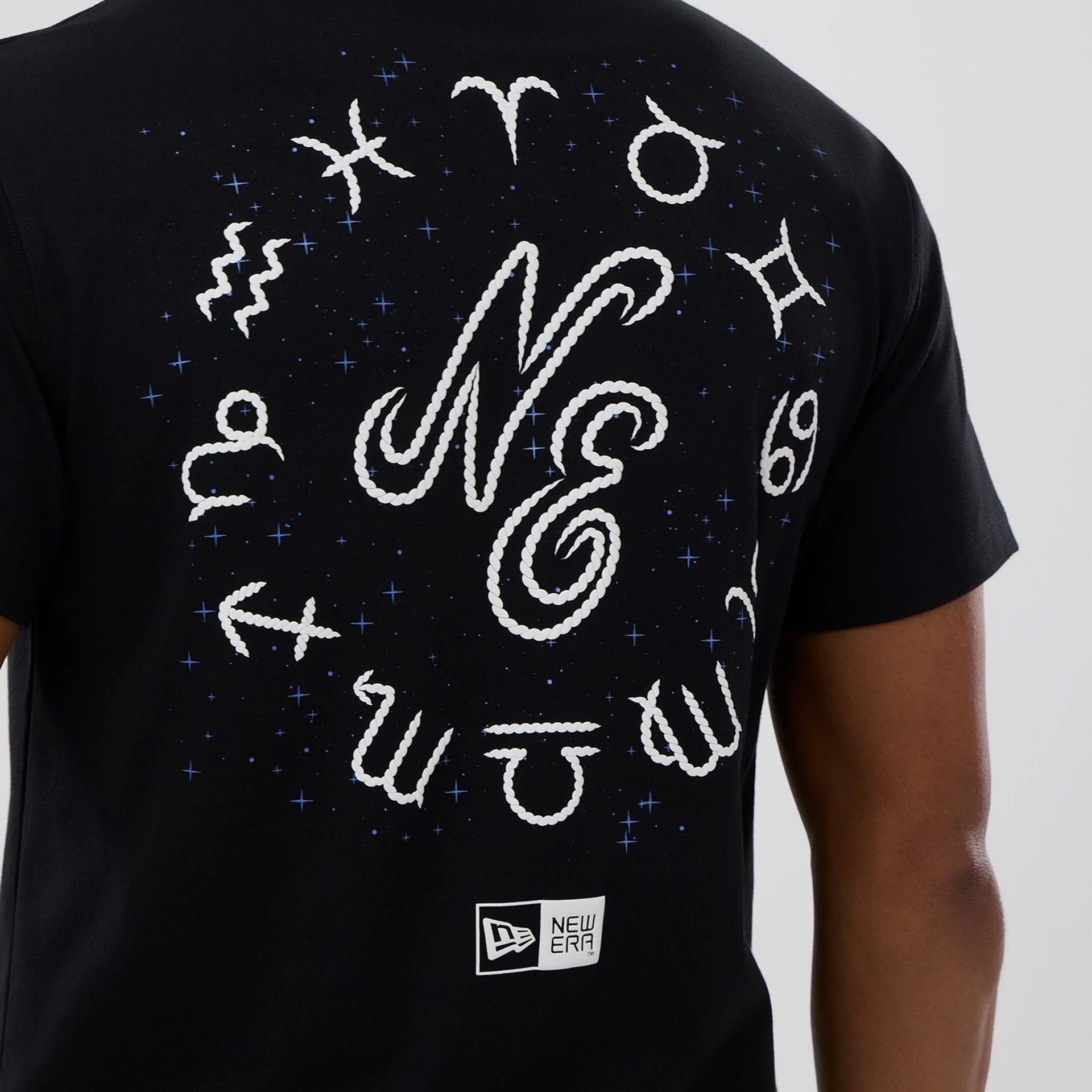The model is wearing this New Era Zodiac Sign T-Shirt in black. 3