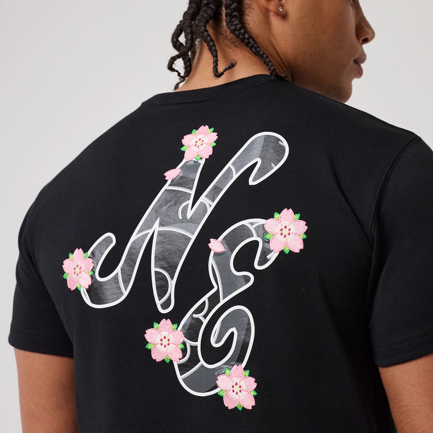 The model is wearing this New Era Sakura T-Shirt in black. 3