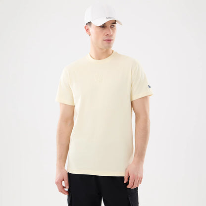 New York Yankees MLB Cartoon Cream T-Shirt, on-model view showing the cream-coloured t-shirt with a debossed New York Yankees logo on the chest and a raised New Era logo on the left sleeve.