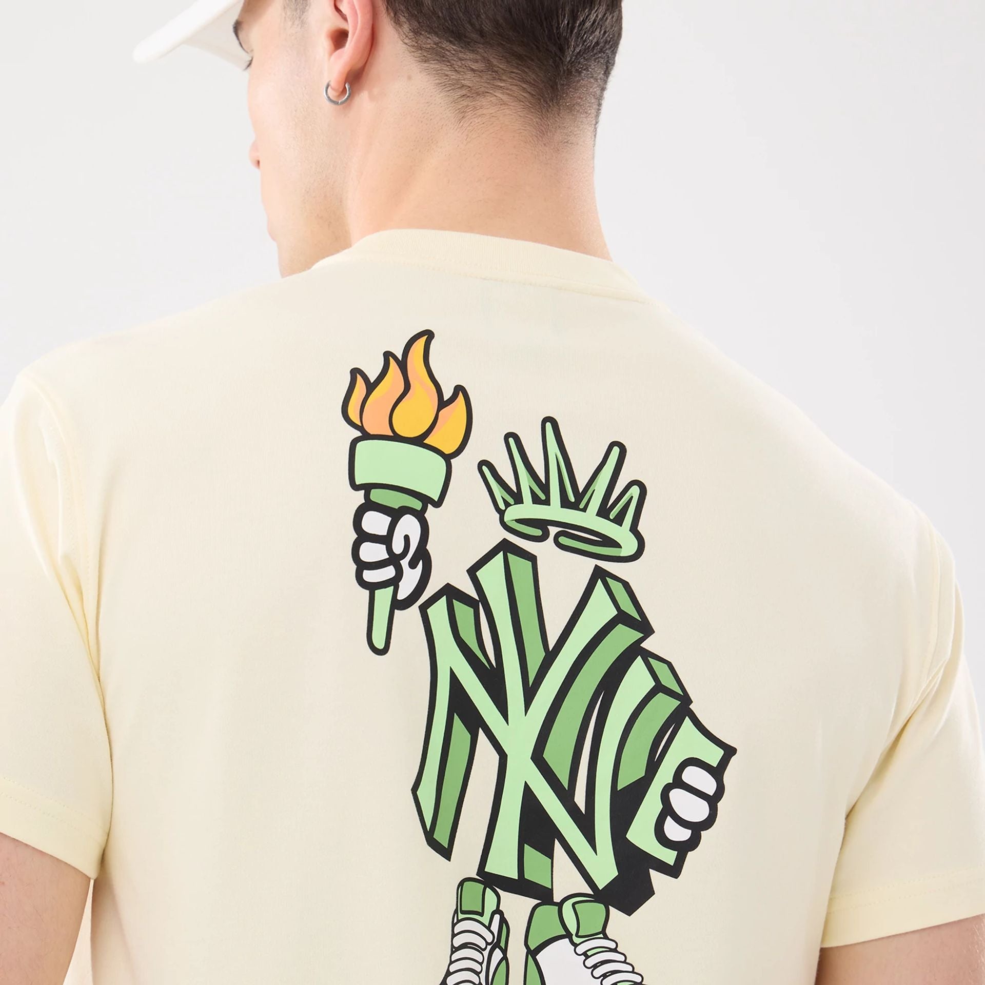 The model is wearing this MLB Cartoon New York Yankees T-Shirt in cream. 7