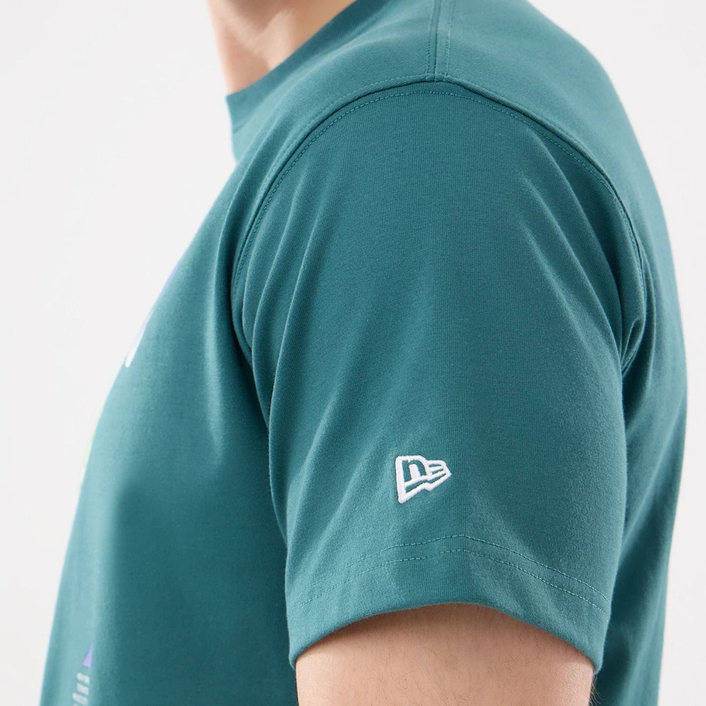 The model is wearing this New Era SK8 Graphic T-Shirt in dark green. 4