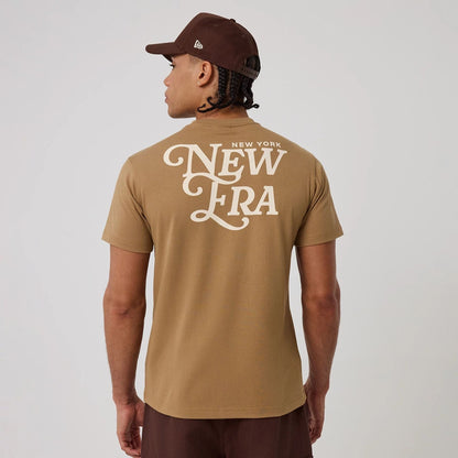 The model is wearing this New Era Script Graphic T-Shirt in Beige. 2