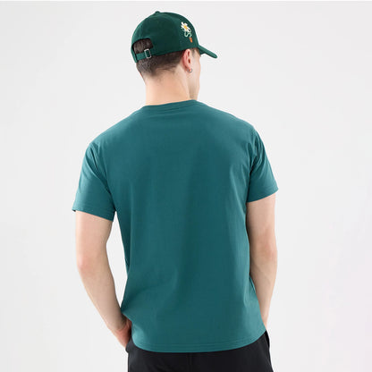 New Era Earth Day Dark Green T-Shirt, on-model view showing the back of the dark green t-shirt, paired with a matching cap that features an embroidered daisy on the side, worn by a person with their hands in pockets.
