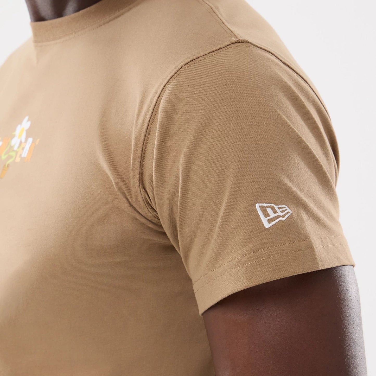 The model is wearing this New Era Earth Day T-Shirt in beige/khaki. 4