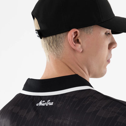 Las Vegas Raiders NFL Black Soccer Jersey, rear view on a model wearing a black cap, featuring a white New Era script logo on the upper back below a black collar with white trim detailing.