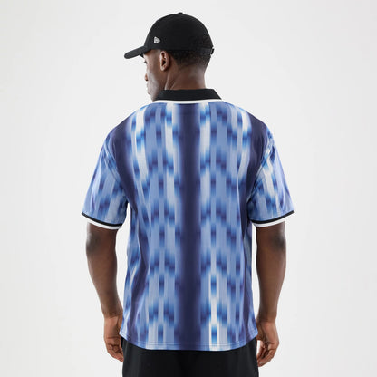 New Era Navy Soccer Jersey, back view on a model wearing a black cap with New Era flag logo, showing a dynamic blue vertical stripe pattern and a black collar with white trim on the sleeves.