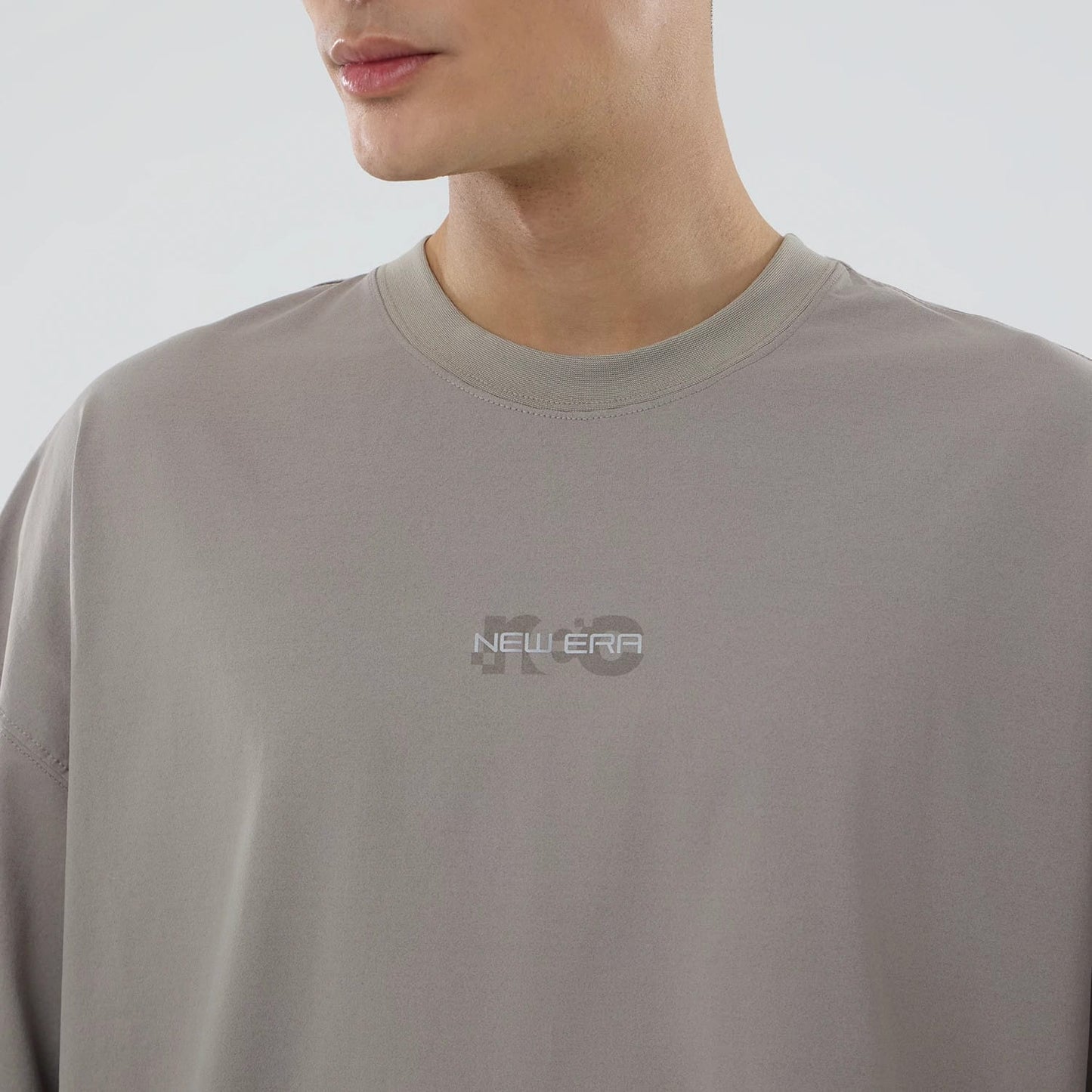The model is wearing this New Era NEC Logo Oversized T-Shirt in Beige. 3