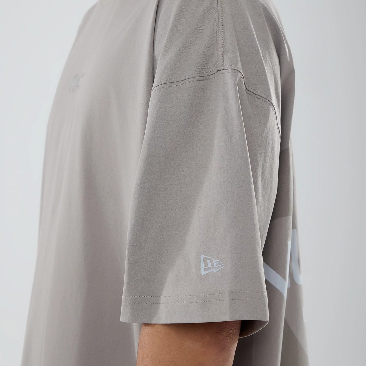 The model is wearing this New Era NEC Logo Oversized T-Shirt in Beige. 6