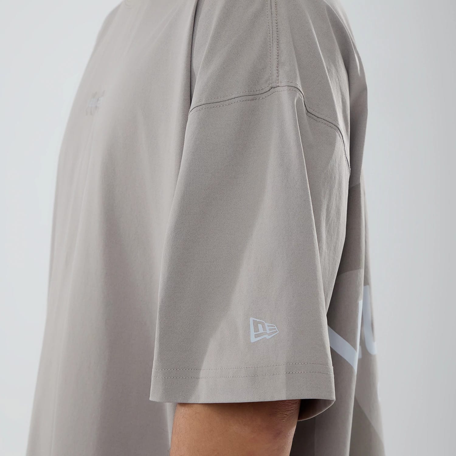 The model is wearing this New Era NEC Logo Oversized T-Shirt in Beige. 6