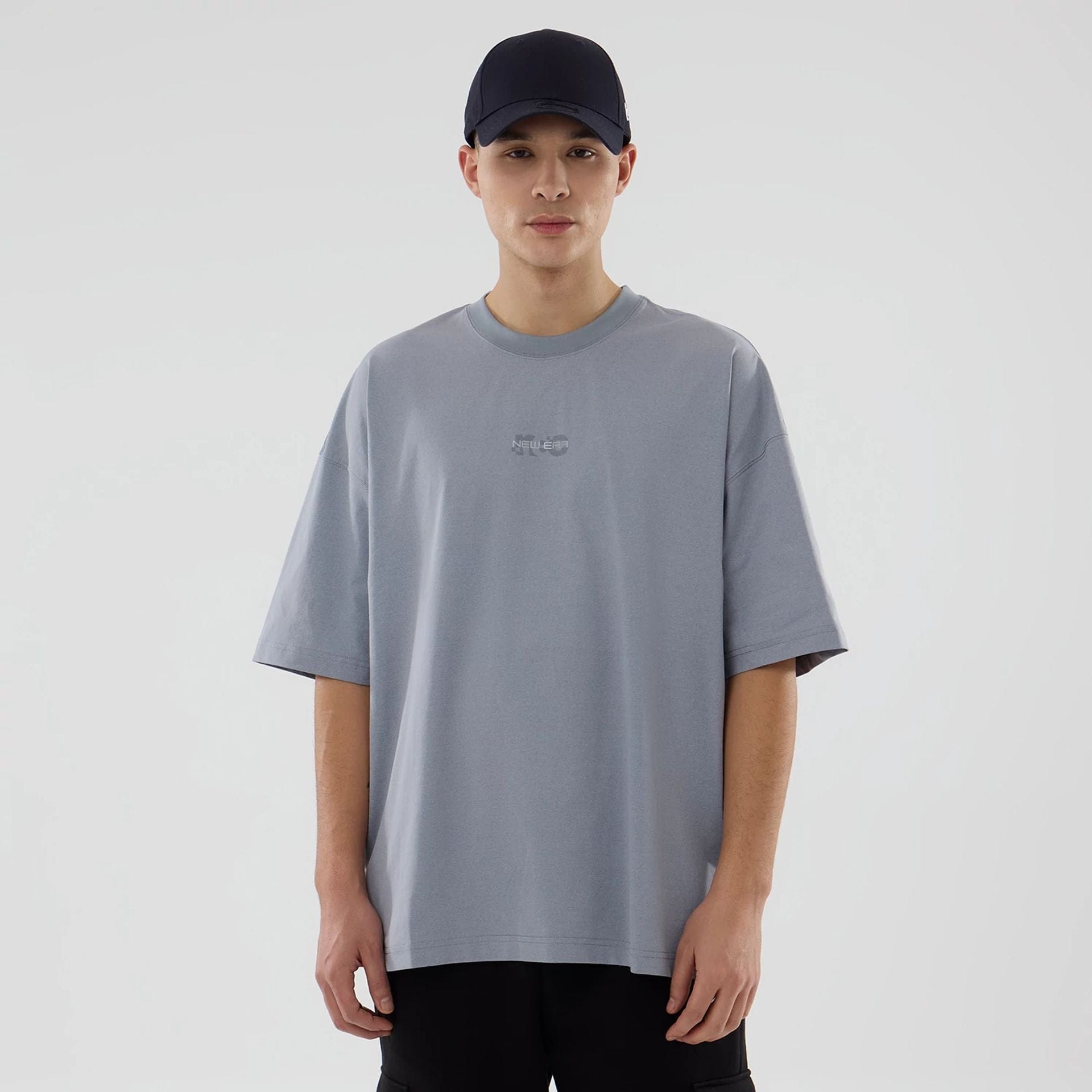 The model is wearing this New Era NEC Logo Oversized T-Shirt in grey. 1