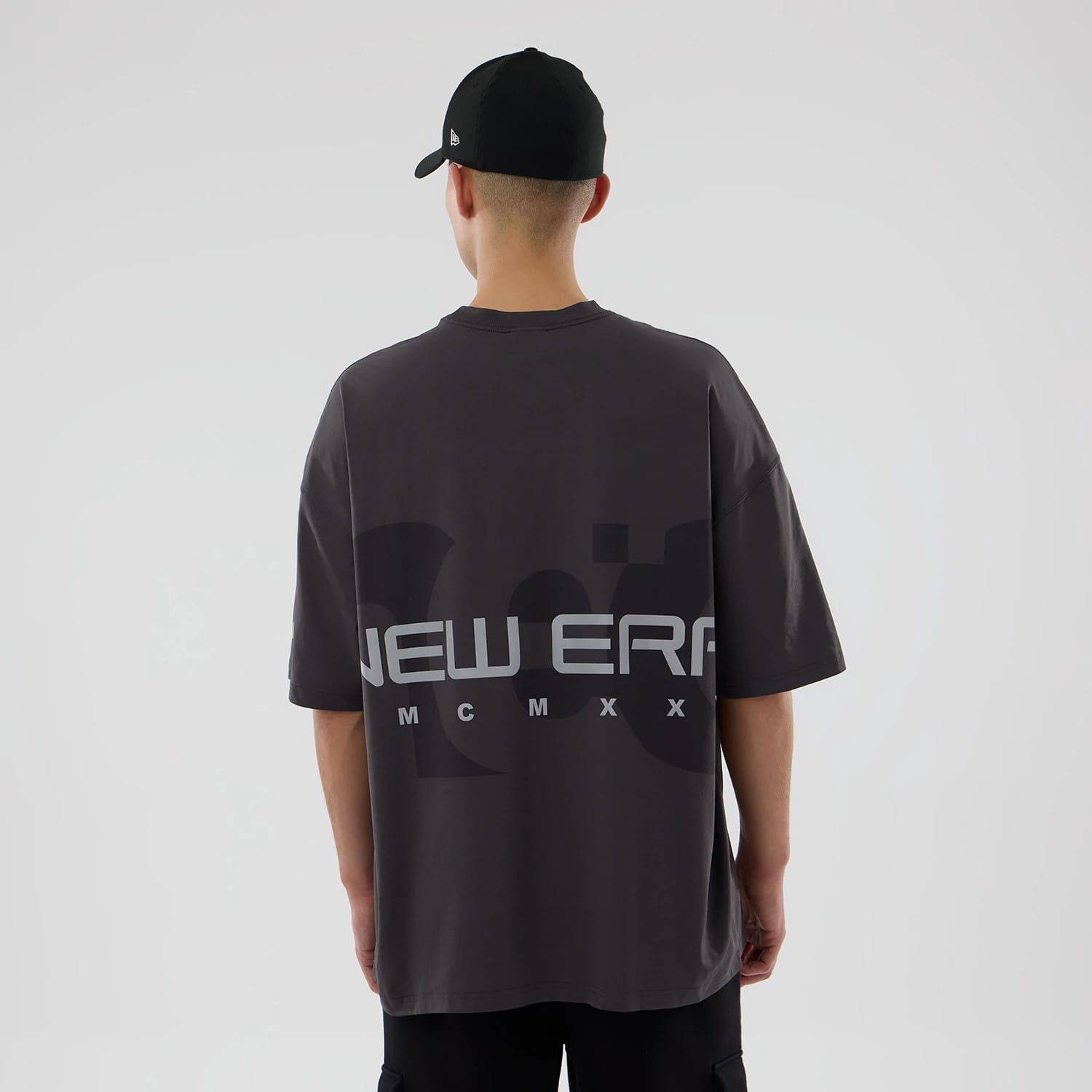 The model is wearing this New Era NEC Logo Oversized T-Shirt in black. 2